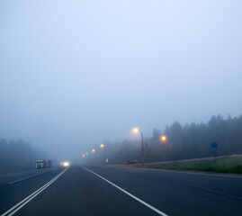 Cars in the fog. Bad weather and dangerous automobile traffic on the road.