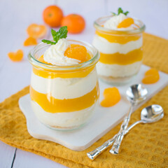 Dessert in jars with whipped cream and mandarin mousse.