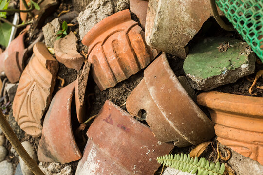 Pieces of shattered and broken terracotta pots scattered on the ground.