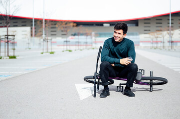 Obraz premium smiling young man sitting on his bicycle