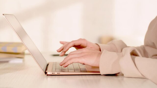 cropped view of freelancer typing on laptop keyboard