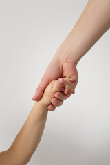 Close up of mothers hand holding child hand.