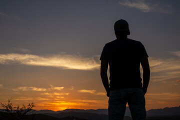 Hombre a contraluz en un atardecer naranja