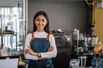 Owner of a coffee shop, an Asian woman, smiling and waiting to serve customers at the coffee shop. Looking camera.