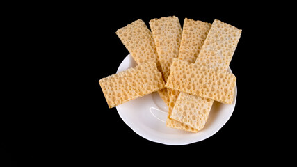 wheat fitness bread on a white saucer on a black background