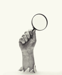 Concept of finding. Man's hand with magnifying glass stick out of hole in paper. Black and white.