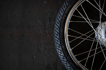 closeup motorcycle tire on old black wood background. top view. flat lay