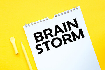BRAIN STORM inscription on white list, yellow pen on a yellow background. a bright solution for business, financial, marketing concept