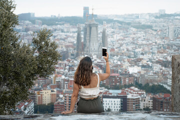 Traveler woman takes a selfie with an anti Covid 19 mask with a beautiful view of the city of...