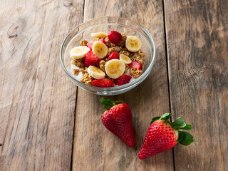 Cereal and fresh fruit bowl isolated on a wooden table, healthy food concept