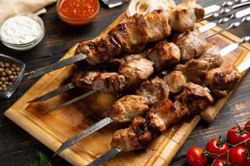 kebabs meat on metal skewer on cutting board rustic style