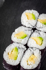 appetizing sushi maki roll avocado on a black stone plate
