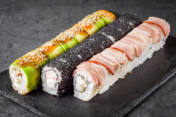 appetizing set of sushi roll on a black stone plate
