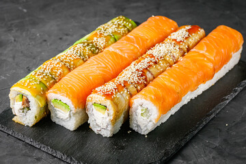 appetizing set of sushi roll on a black stone plate