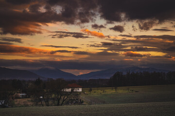 Fototapeta na wymiar Sunset in countryside with mountains in the distance
