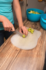 closeup of hands on latin girl cutting green grapes