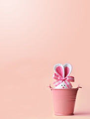 Easter holiday concept with cute handmade egg, bucket and bunny ears.