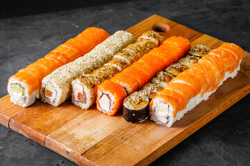 appetizing set of sushi roll on a black stone plate