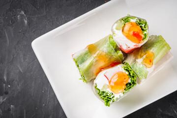 appetizing spring rolls with sea food and philadelphia cheese on a darck background