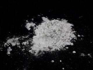Cocaine drug powder pile on black background