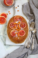 Sponge cake with red oranges on gray background