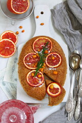 Sponge cake with red oranges on gray background