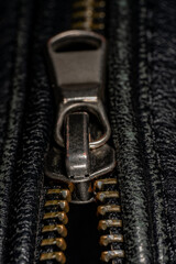 Detail of locking zipper on black leather jacket. Close up macro local focus shot. Vertical macro photography view.