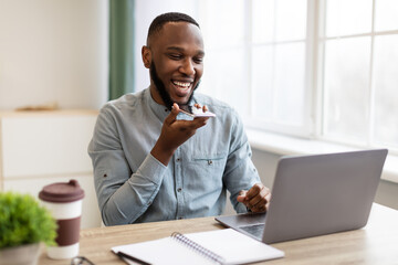 African Businessman With Smartphone Using Voice Assistant App In Office