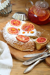 Sponge cake with red oranges on gray background