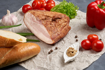 Traditional smoked pork with skin on paper with vegetables and mustard. Classic meat products.