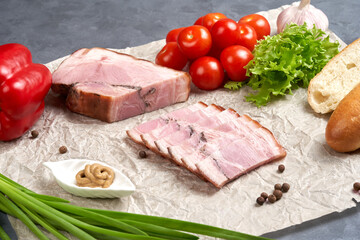 Traditional slicing of smoked pork on paper with tomatoes, onions and mustard. Classic meat products, delicacies.