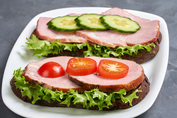 Two ham sandwiches on a plate. Selective focus. Close-up.