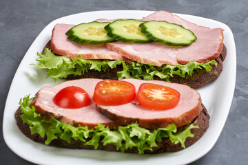 Two ham sandwiches on a plate. Selective focus. Close-up.