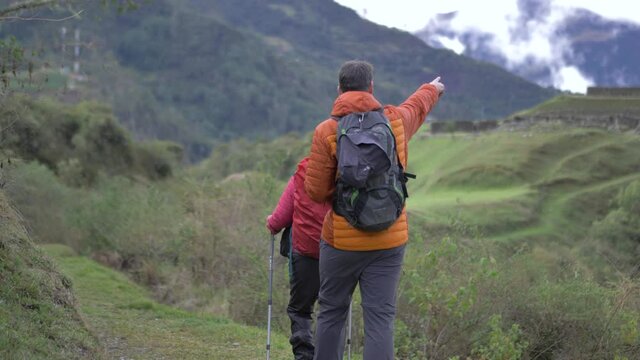 Couple walking to Archaeological inca ruins, in middle of the mountains, vitcos, road to vilcabamba, machu picc