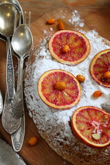 Sponge cake with red oranges on gray background