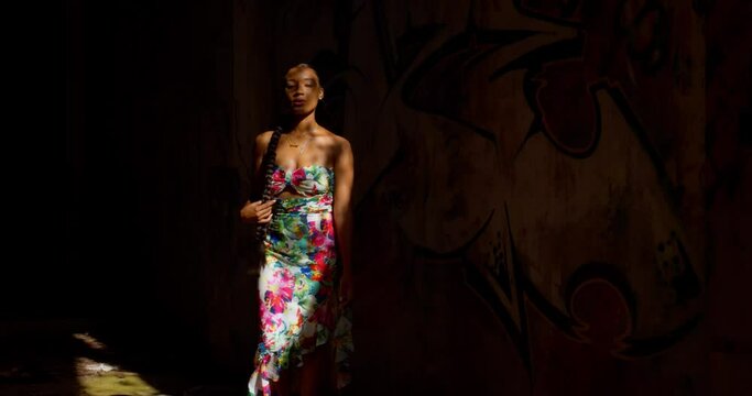 Epic darkness to light model shoot as a girl walks out from an abandoned warehouse
