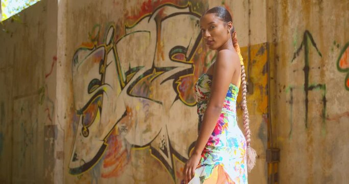Amazing model standing in an abandoned warehouse with grafitti on the wallks in the background