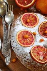 Sponge cake with red oranges on gray background