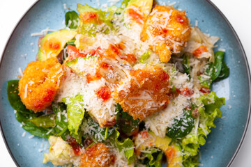 Close up photo of sea salad with shrimps avocado and cheese.