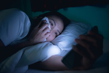 Asian woman playing game on smartphone in the bed at night,Thailand people,Addict social media