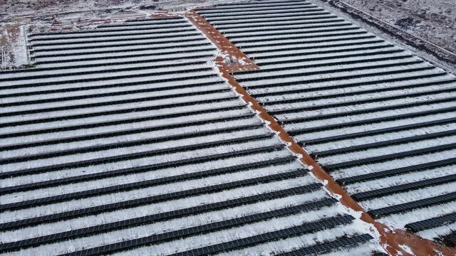 Cinematic Top Down Aerial View On Graphic Straight Lines Of Solar Power Panels In Snowy Field In Winter. Drone Shoots Video Of Energy Saving And Concept Of Alternative Power Source