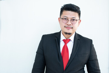 Handsome young business man wear glasses red tie in a suit and west.