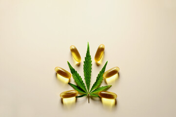 Medicinal cannabis leaf with marijuana oil in capsules on white background.