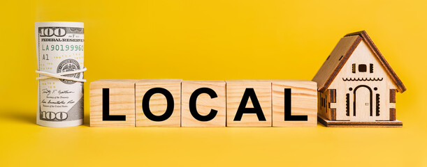 Obraz premium LOCAL with house miniature model and money on a yellow background. The concept of business, finance, credit, tax , real estate, home, housing