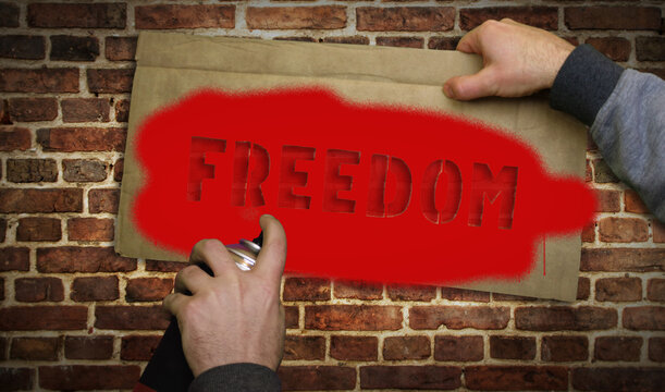 Freedom spray painted inscription on the brick wall