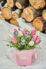 bouquet of spring flowers on a background of woodpile with large logs