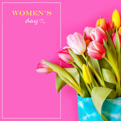 8 march post blog for social media. Banner mockup for woman's day. Spring bouquet of colorful tulips in blue textile eco packaging on a pink background with a frame and a place for a greeting text