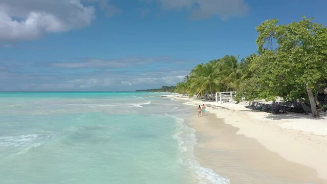 A fit couple walking in the sea on a beautiful sandy beach in Saona Dominican republic luxury holiday