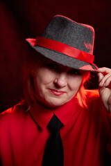 Portrait of fat plump chubby middle-aged woman with hat. Model posing in male style in the Studio.