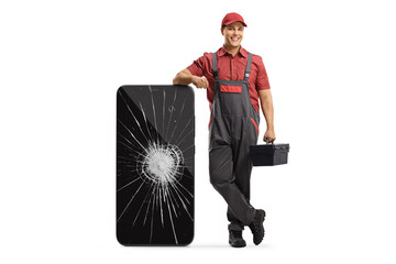 Mobile phone repair technician leaning on a smartphone with a broken screen